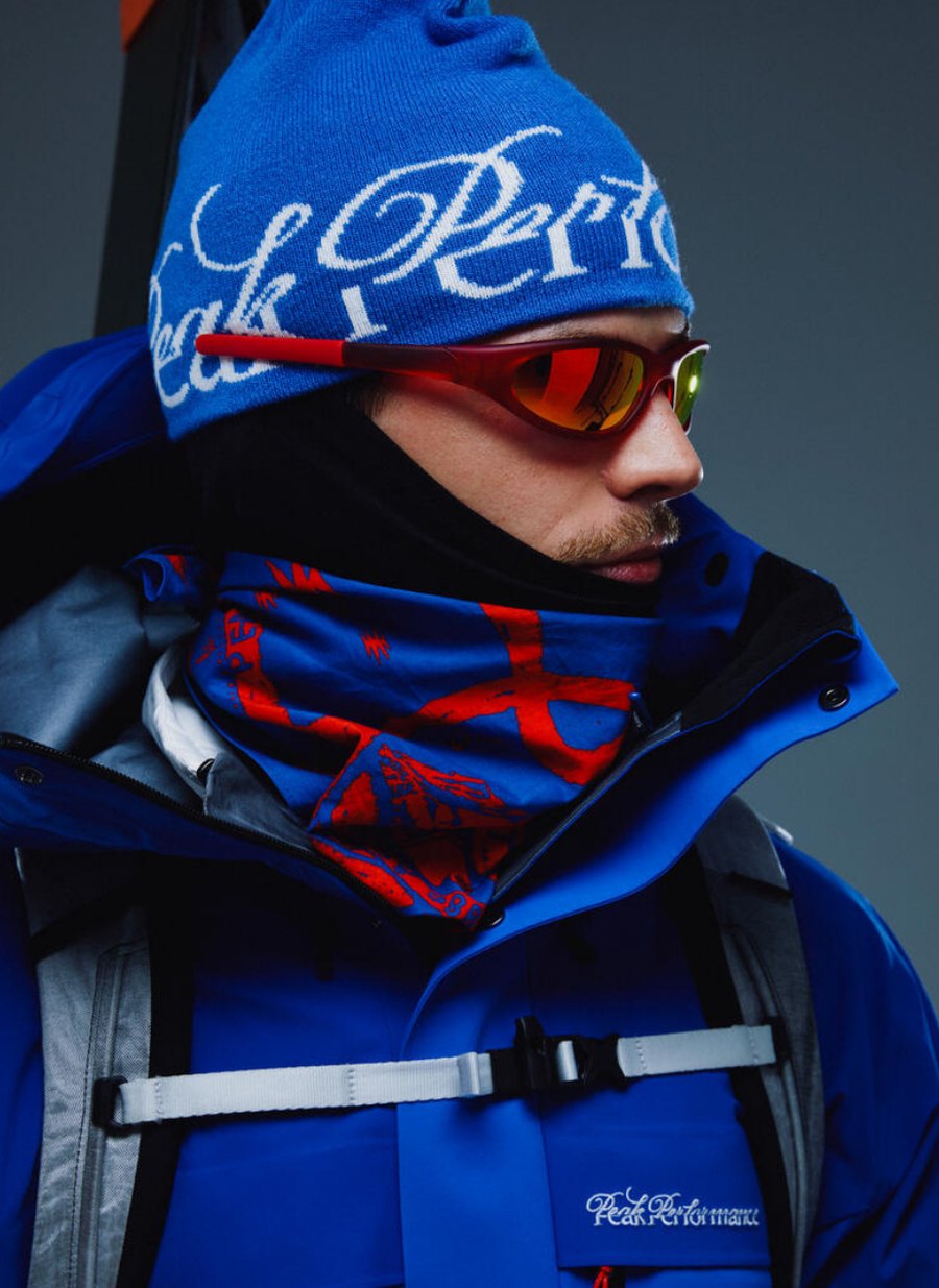 Model wearing a Peak Performance 40Y beanie, goggles and blue GORE-TEX ski jacket